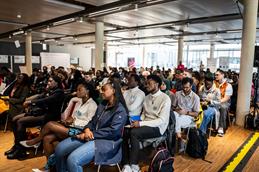 Zahlreiche Teilnehmende des African Students Day 2026 sitzen in einer Mensa und verfolgen aufmerksam das Programm.